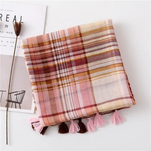 Detail of pink and orange plaid scarf with dual-tone tassels and soft fringe texture