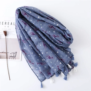 Detail of colorful deer print on blue scarf with handmade fringe and star patterns