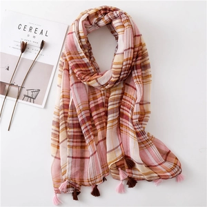 Plaid cotton linen shawl with fringe in pink and orange tones on a minimalist white background