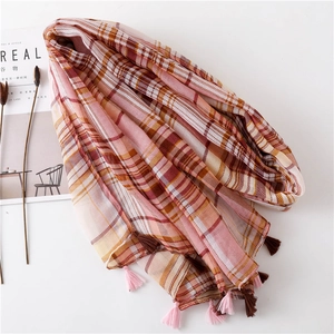 Detail of plaid cotton scarf with pink fringe tassels and light orange check patterns