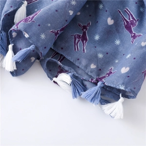 Detailed close-up of blue scarf with colorful deer print and fringed tassel edges