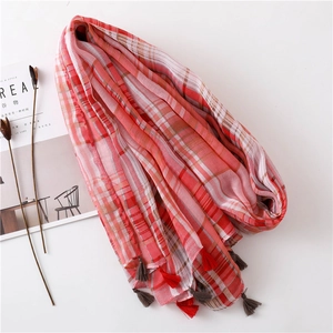 Detail of red and white plaid cotton scarf with handmade dual-color tassels on edges