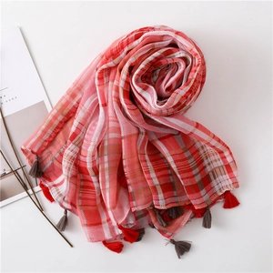 Detailed view of plaid scarf with soft red tassels and intricate cotton linen weave
