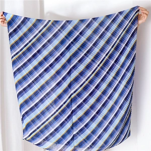 Detailansicht eines großen Sommer-Strandschals mit blau-gelben diagonalen Streifen-Textur