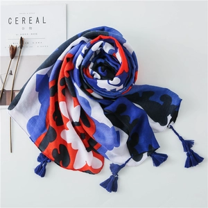 Blue abstract floral scarf with tassels on minimalist white background with dry flowers