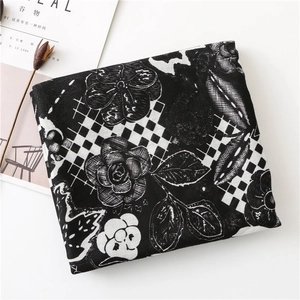 Detail of black and white floral print scarf with checkerboard pattern and magazine