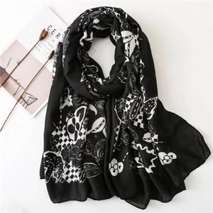 Detail of artistic skull and floral print on lightweight scarf with frayed edges