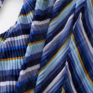 Nahaufnahme von plissiertem Streifenstoff in Blau und Gelb für Sommerschals