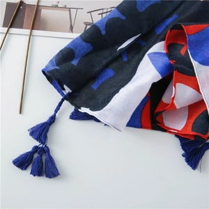 Close-up of abstract blue and red patterned scarf with fine tassel fringe detail