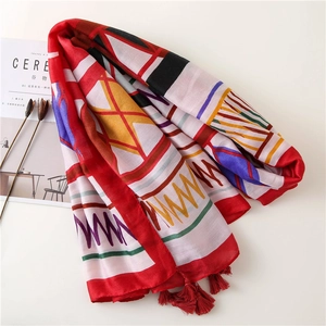 Ethnic geometric pattern beach shawl with red tassels on minimalist white background