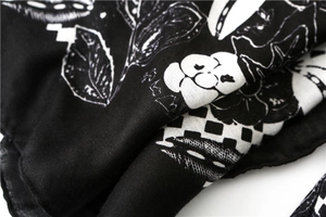 Macro detail of black and white floral pattern on soft cotton linen scarf fabric
