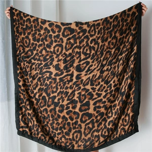 Detail of soft leopard print shawl showing the premium black stitched edges and fabric texture