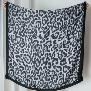 Detail of grey leopard print cotton linen shawl with black stitched border and wide wrap