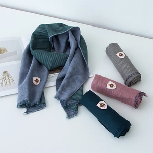 Detail of four colorful scarves with tassels and premium leather labels for kids