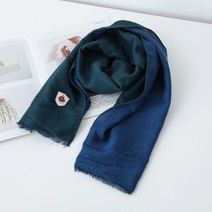 Close-up of dual-tone cotton linen scarf with vintage label and fringe edges