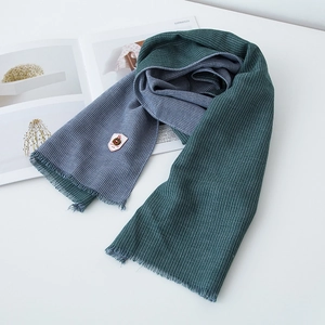 Detail of dual-sided cotton linen scarf featuring dark green and blue checkered patterns