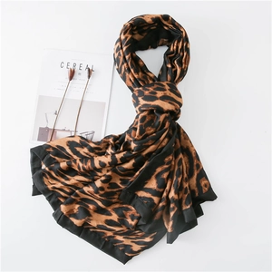 Detail of leopard print shawl with black stitched edges on minimalist magazine background