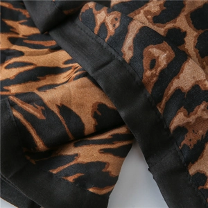 Detail of leopard print cotton linen shawl showing premium black hem stitching and fabric texture