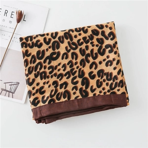 Detail of leopard print cotton-linen scarf with brown edge and magazine prop