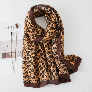Detail of leopard print cotton linen scarf with elegant thick dark borders on white