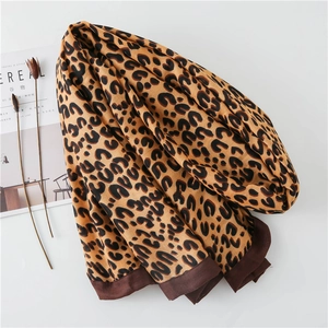 Detail of leopard print cotton linen scarf with thick brown hem and elegant dry flowers
