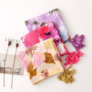 Detail of three watercolor floral cotton linen scarves with long fringe tassels
