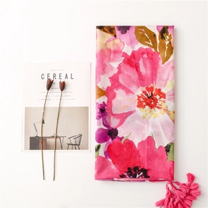 Detail of floral linen-feel scarf with tassel fringe alongside a Cereal magazine
