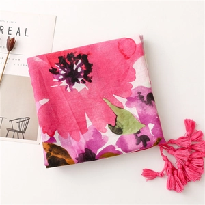 Detail of vibrant floral linen scarf with long pink fringe and soft textured fabric
