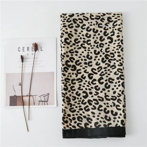 Detail shot of leopard print scarf featuring wide black hem and soft cotton-linen texture