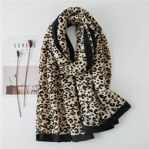 Close-up of leopard print scarf with black borders on minimalist magazine background