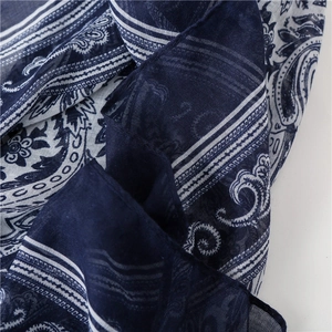 Detailed macro view of navy blue paisley floral pattern on woven cotton linen scarf
