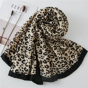 Detail of soft leopard print shawl with thick black borders on a minimalist background