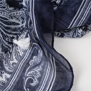 Detailed macro view of ethnic paisley print on woven scarf with decorative tassels