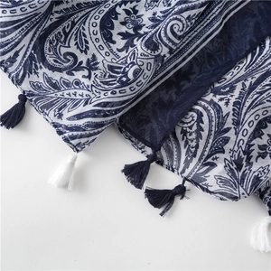 Detail of navy blue ethnic paisley shawl featuring delicate tassels and cotton texture