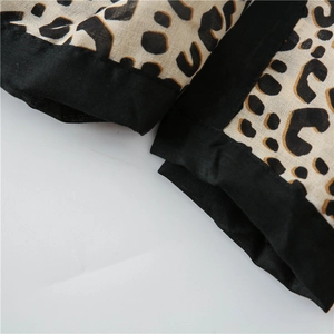 Detailed view of the leopard print cotton linen shawl with wide black stitched edge finish