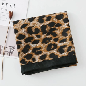 Detail shot of leopard print scarf with black border on minimalist white background