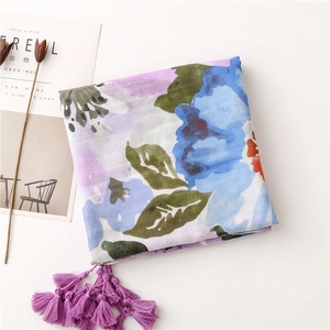 Close-up of floral print linen-feel scarf featuring purple tassels and soft pastel colors