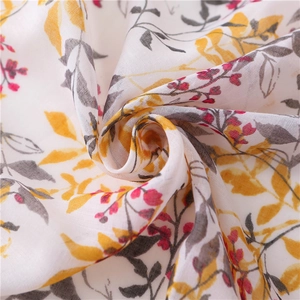 Macro shot of cotton linen scarf with yellow leaf print and fringe details