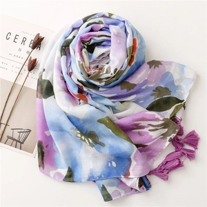Detail of floral linen-feel scarf featuring purple tassel trim and soft gradient print