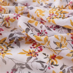Close-up of lightweight cotton linen scarf with yellow leaf and red berry floral patterns