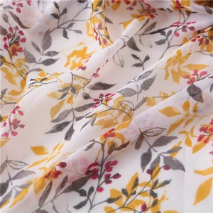 Detailed macro view of yellow floral print on soft cotton linen scarf with elegant drapes