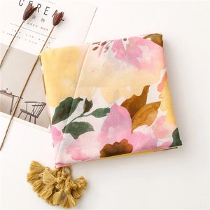 Detail of floral linen shawl with pink and yellow watercolor print and golden tassels
