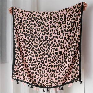 Close-up of leopard print scarf with pink and black fringe trim and soft fabric detail