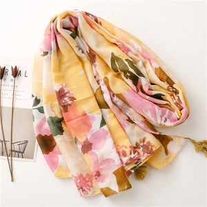 Detail of yellow and pink floral cotton-linen scarf with delicate tassel edge trim