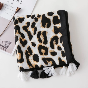 Detail of leopard print scarf with tassels alongside Cereal magazine on white surface