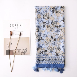 Detail of light blue floral scarf with vintage prints and delicate tassel edges