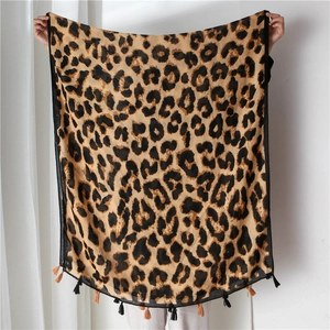 Detail view of leopard print cotton linen scarf featuring alternating brown and black tassels