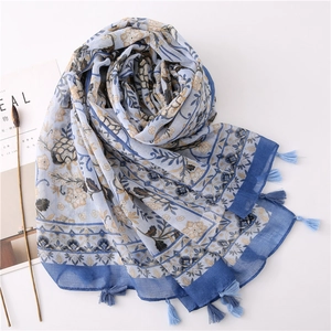 Detail of vintage floral scarf with blue tassels and intricate ethnic patterns