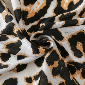 Macro view of leopard print scarf texture showing soft cotton linen weave details