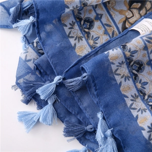 Detail of blue floral patterns on 100% acrylic shawl with soft fringe tassels